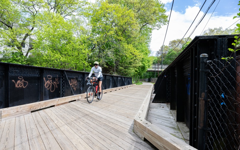 Baker Chocolate Factory Lifestyle Man Biking Down a Path